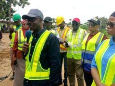 RAAMP: Oyo Govt Completes 88.02 Km Of Rural Roads, Markets In Phase One Of Project Group of people in high-visibility vests at a construction site, a man in a cap speaks into a microphone while others listen.