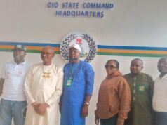 SYDI DG, POCACOV Southwest Chairman Visit Oyo CP Over Abduction In Oriire Six people stand side by side in front of a wall reading 'OYO STATE COMMAND HEADQUARTERS,' with a circular emblem and colored stripes behind them.