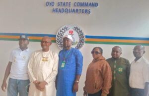 SYDI DG, POCACOV Southwest Chairman Visit Oyo CP Over Abduction In Oriire Six people stand side by side in front of a wall reading 'OYO STATE COMMAND HEADQUARTERS,' with a circular emblem and colored stripes behind them.