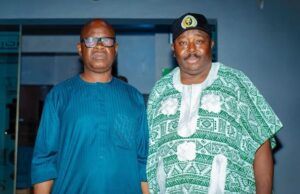 2027: Jubril Dotun Sanusi Hosts Oyo APC Guber Aspirant, Sharafadeen Alli, Discuss Tinubu’s Re-election Plan Two men standing indoors; one wears a blue traditional outfit with glasses, the other a green-and-white patterned agbada with a cap.