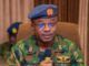 Take Fight To Terrorists, Air Staff Chief Tasks Personnel Nigerian Air Force officer in camouflage uniform speaking into a handheld microphone, wearing a blue beret with the force insignia.