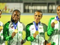 African Senior Athletic Championships: Team Nigeria Wins More Medals Four female athletes in green-and-white jackets hold gold medals, smiling on a track field during an awards ceremony.