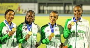 African Senior Athletic Championships: Team Nigeria Wins More Medals Four female athletes in green-and-white jackets hold gold medals, smiling on a track field during an awards ceremony.