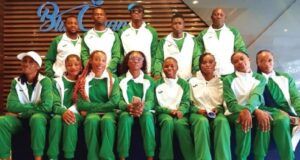 Tinubu Charges Team Nigeria To Excel At World Athletics Relays Group of athletes in matching green and white tracksuits posing for a team photo indoors.