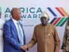 Tinubu Approves Nigeria’s Hosting Of 2026 CAF Congress, Awards Four people stand in front of an Africa Awards backdrop; two men shake hands while the others look on at a formal event in Nairobi.