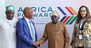Tinubu Approves Nigeria’s Hosting Of 2026 CAF Congress, Awards Four people stand in front of an Africa Awards backdrop; two men shake hands while the others look on at a formal event in Nairobi.