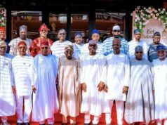 I’m Happy States No Governors Struggle To Pay Salaries—Tinubu Group of men in traditional Nigerian attire posing for a photo on a red carpet at an Eid celebration, with floral decorations in the background.