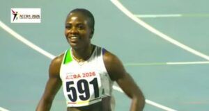 Accra 2026: Amusan Wins Women’s 100m Hurdles Gold Male sprinter wearing bib 591 on a blue track during ACCRA 2026, smiling after a race wear white-green uniform