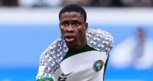 We Are Here To Win The Unity Cup —Tochukwu Nnadi Nigerian national team footballer in white kit with green trim, number 8, sprinting on the field in action.