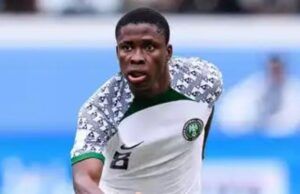 We Are Here To Win The Unity Cup —Tochukwu Nnadi Nigerian national team footballer in white kit with green trim, number 8, sprinting on the field in action.