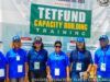 ‘Universities Judged By Research Relevance, Impact, Not Infrastructure’ Group of seven people in blue uniforms posing in front of a banner that says 'TETFUND Capacity Building Training' at a training event.