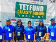 ‘Universities Judged By Research Relevance, Impact, Not Infrastructure’ Group of seven people in blue uniforms posing in front of a banner that says 'TETFUND Capacity Building Training' at a training event.
