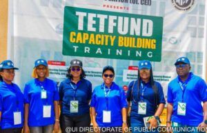 ‘Universities Judged By Research Relevance, Impact, Not Infrastructure’ Group of seven people in blue uniforms posing in front of a banner that says 'TETFUND Capacity Building Training' at a training event.