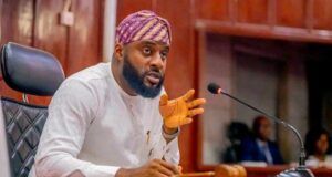 Oriire Abduction: Oyo Assembly Urges FG To Expedite Action On State Police Bearded man in white traditional attire and purple turban speaks into a microphone at a panel desk.