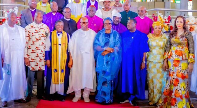 Akpabio church Group of dignitaries posing for a ceremony photo in colorful traditional attire on a red carpet