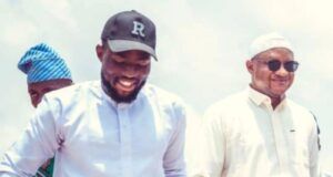 Barr Akeem Agbaje Celebrates Asiwaju Adekola Mudashir On Birthday Three men walking outdoors, smiling; center man in a white kurta, cap with 'R', right man in sunglasses.