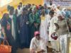 NOA Chief, Kayrom Lee Charge Musicians To Emulate Barrister’s Legacy Large group of people in colorful traditional African clothing posing on steps at an outdoor event.