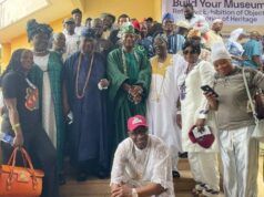NOA Chief, Kayrom Lee Charge Musicians To Emulate Barrister’s Legacy Large group of people in colorful traditional African clothing posing on steps at an outdoor event.