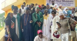 NOA Chief, Kayrom Lee Charge Musicians To Emulate Barrister’s Legacy Large group of people in colorful traditional African clothing posing on steps at an outdoor event.