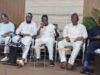 Guber 2027: Five Aspirants Call For Oyo APC Chairman’s Resignation Five men seated in a row at a conference, one speaking into a microphone while others listen, in traditional outfits with neutral backdrop.