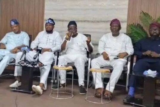 Guber 2027: Five Aspirants Call For Oyo APC Chairman’s Resignation Five men seated in a row at a conference, one speaking into a microphone while others listen, in traditional outfits with neutral backdrop.