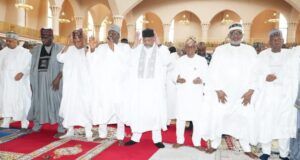 2026 Democracy Day: Be Hopeful For Peace, Unity; Clerics Urge Nigerians Group of men in white traditional robes and caps standing on a red prayer rug inside a mosque, some with hands raised in prayer.