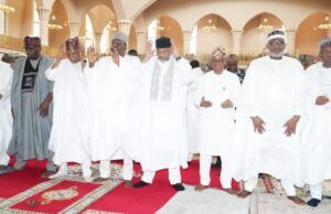 2026 Democracy Day: Be Hopeful For Peace, Unity; Clerics Urge Nigerians Group of men in white traditional robes and caps standing on a red prayer rug inside a mosque, some with hands raised in prayer.