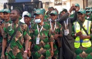 2026 Hajj: Oyo’s First, Second Batch Pilgrims Set For Return To Nigeria Group of men in matching green camouflage outfits and green caps posing together, some with lanyards and a high-visibility vest in the crowd.