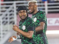 “Come To Galatasaray,” Osimhen Urges Lookman Two Nigerian football players in green and black patterned jerseys celebrate on the pitch during a match.