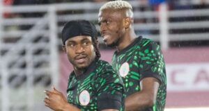 “Come To Galatasaray,” Osimhen Urges Lookman Two Nigerian football players in green and black patterned jerseys celebrate on the pitch during a match.