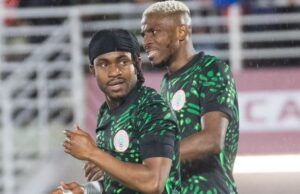 “Come To Galatasaray,” Osimhen Urges Lookman Two Nigerian football players in green and black patterned jerseys celebrate on the pitch during a match.