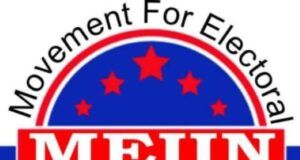 MEIIN Celebrates Democracy Day, Praises Tinubu’s Role In Nigeria’s Democratic Struggle Logo for Movement For Electoral Integrity In Nigeria (MEIN): circular emblem with a red banner reading 'JUSTICE & FAIR PLAY', blue field with red stars, and Nigerian flag colors around the edge.