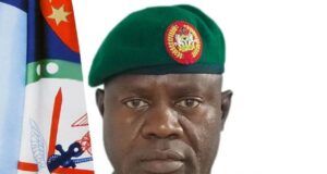 Nigeria-U.S. Partnership Has Weakened ISIS Operations – DHQ Portrait of a green-uniformed military officer with a beret, ribbons, and medals, standing before a flag backdrop.