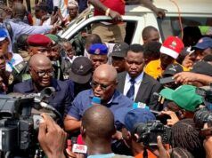 Oyo School Abduction: Obasa Reaffirms Push For State Police Amid NUT Protest Politician or speaker addressing a crowded media scrum with multiple cameras and microphones around him near a white vehicle.