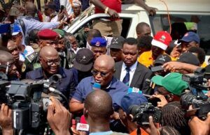 Oyo School Abduction: Obasa Reaffirms Push For State Police Amid NUT Protest Politician or speaker addressing a crowded media scrum with multiple cameras and microphones around him near a white vehicle.