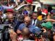 Oyo School Abduction: Obasa Reaffirms Push For State Police Amid NUT Protest Politician or speaker addressing a crowded media scrum with multiple cameras and microphones around him near a white vehicle.