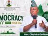 Democracy Day: Hon. Omikunle Celebrates Nigeria’s Heroes, Prays for Peace In The Nation Banner for Nigeria's Democracy Day with a man in traditional attire speaking into a microphone; text reads 'Happy Democracy Day Nigeria June 12' and 'Our Voice. Our Right. Our Future.' with Nigerian flag visuals and 'Hon. Olayinka Omikunle' on a green badge.