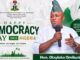 Democracy Day: Hon. Omikunle Celebrates Nigeria’s Heroes, Prays for Peace In The Nation Banner for Nigeria's Democracy Day with a man in traditional attire speaking into a microphone; text reads 'Happy Democracy Day Nigeria June 12' and 'Our Voice. Our Right. Our Future.' with Nigerian flag visuals and 'Hon. Olayinka Omikunle' on a green badge.