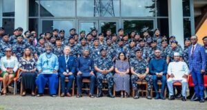 IGP Charges Officers To Drive Police Reform, Embrace Innovation Large group photo of uniformed military personnel and civilian officials seated in front of a glass-front building outdoors.