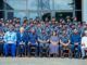 IGP Charges Officers To Drive Police Reform, Embrace Innovation Large group photo of uniformed military personnel and civilian officials seated in front of a glass-front building outdoors.