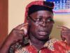 Insecurity: MURIC Urges Southwest Govs To Strengthen Amotekun, OPC Man in a bright shirt and red head wrap gestures with his fingers at his temples, speaking with a serious expression (appears to be making a point).