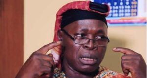 Insecurity: MURIC Urges Southwest Govs To Strengthen Amotekun, OPC Man in a bright shirt and red head wrap gestures with his fingers at his temples, speaking with a serious expression (appears to be making a point).