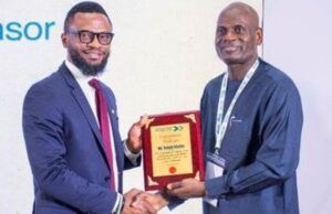 Shell Identifies Strategic Pathways To Advance Gas Utilisation At Abuja Business Forum Two men in business attire shake hands as one presents a wooden plaque award
