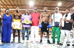 Glorious Promotions Stages ‘Fight Until The Killings Stop’ Boxing Show Group of boxers and coaches posing in a boxing ring; one fighter wears a championship belt across the waist.