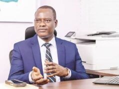 Federal Gov’t Cuts Ministers’ Imprest To N700,000, Tightens Spending Rules Professional man in a blue suit seated at a desk in an office, gesturing with his hands as he speaks.