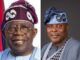 APC Support Groups Council Endorses Tinubu For Second Term On Democracy Day Two Nigerian men in traditional attire posing side by side: the left is an older man with a purple cap and glasses, the right is a younger man in a blue agbada with a matching patterned cap, both smiling.